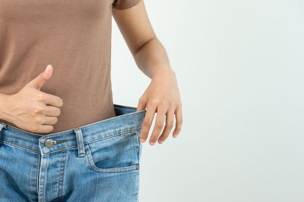 A person who has recently lost weight has a thumbs up