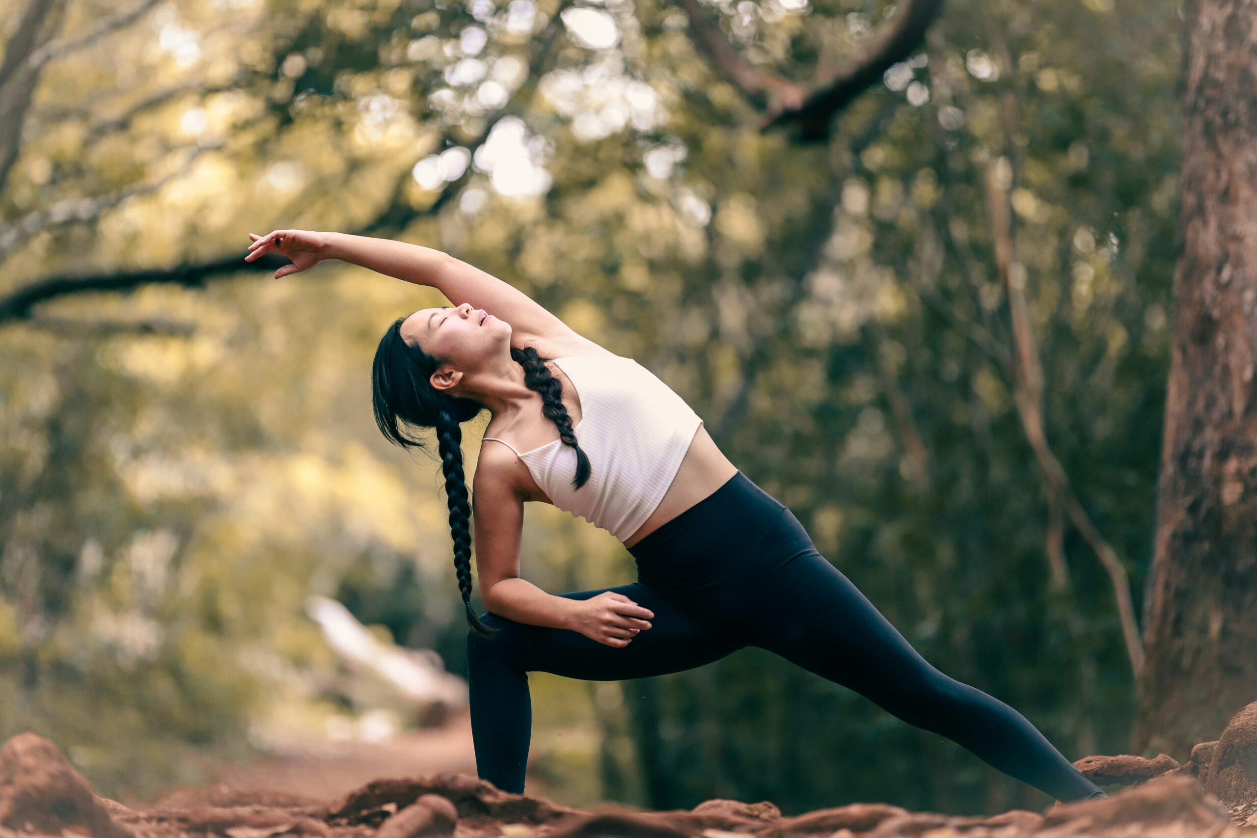 Individual performing side angle yoga pose outdoors, embracing nature and mindful movement.