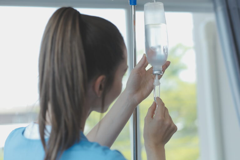 woman putting IV in arm
